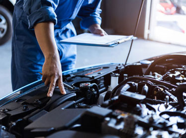 Technician with a clipboard inspecting an engine
