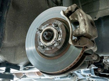 Brake rotor and caliper on a car raised for service