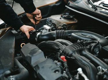 Mechanic working on an engine with the hood open