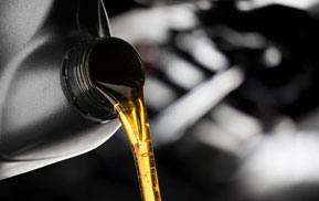 Fresh motor oil being poured into an engine