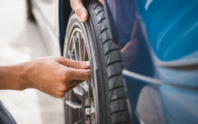 Technician checking a tire on a car wheel