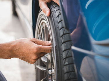 Technician checking the tread of a car's tire